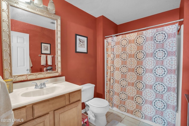 bathroom with vanity, toilet, tile patterned flooring, and a textured ceiling