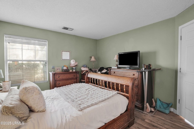 bedroom featuring hardwood / wood-style flooring and a textured ceiling