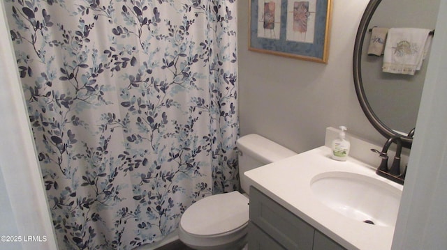 bathroom featuring curtained shower, vanity, and toilet