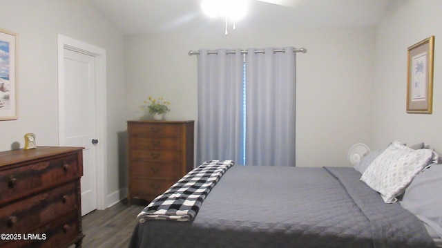 bedroom featuring lofted ceiling and dark wood-style flooring