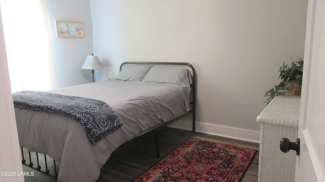 bedroom featuring baseboards and wood finished floors