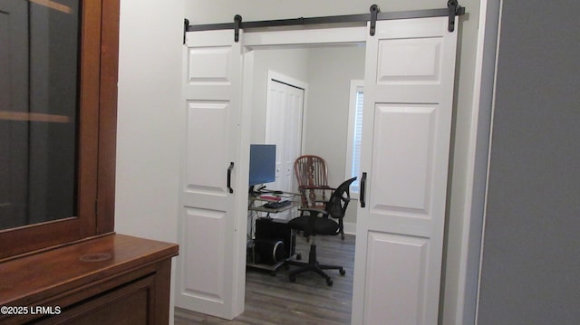 home office featuring wood finished floors and a barn door