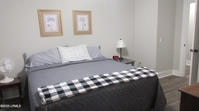 bedroom featuring baseboards and dark wood-type flooring