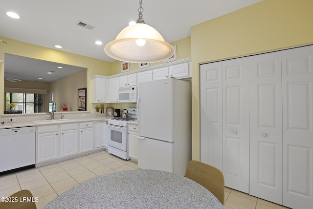 6 Callisto Rd, Okatie, SC 29909 - kitchen with white appliances, light tile patterned floors, light countertops, white cabinets, and decorative light fixtures