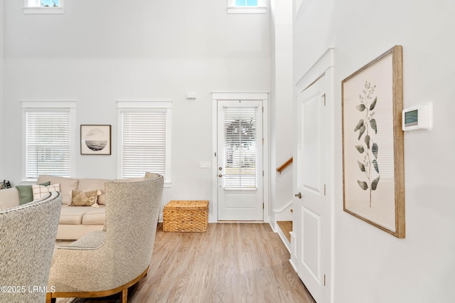 foyer with light wood-type flooring and a high ceiling