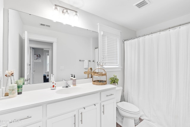 full bathroom featuring toilet, visible vents, and vanity