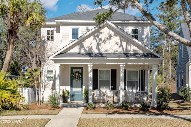 view of front of property featuring covered porch and fence