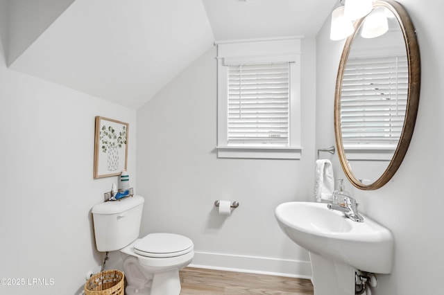 bathroom with toilet, baseboards, wood finished floors, and lofted ceiling