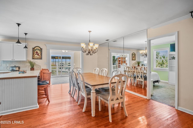 373 Pike Dr, Fripp Island, SC 29920 - dining area featuring a chandelier, plenty of natural light, light wood-style floors, and crown molding