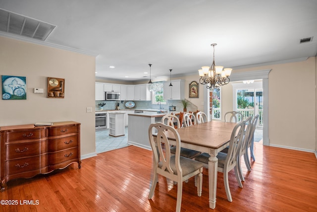 373 Pike Dr, Fripp Island, SC 29920 - dining room featuring a chandelier, light wood-style floors, ornamental molding, healthy amount of natural light, and recessed lighting