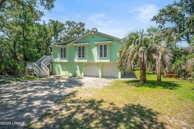 373 Pike Dr, Fripp Island, SC 29920 - coastal inspired home with stairway, a front lawn, a garage, driveway, and a chimney