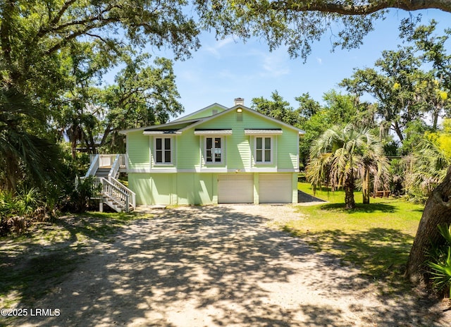 373 Pike Dr, Fripp Island, SC 29920 - view of front facade with stairs, dirt driveway, a garage, and a chimney