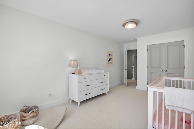 bedroom featuring a closet, baseboards, and light carpet