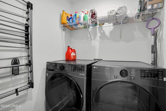 clothes washing area with washing machine and clothes dryer and laundry area