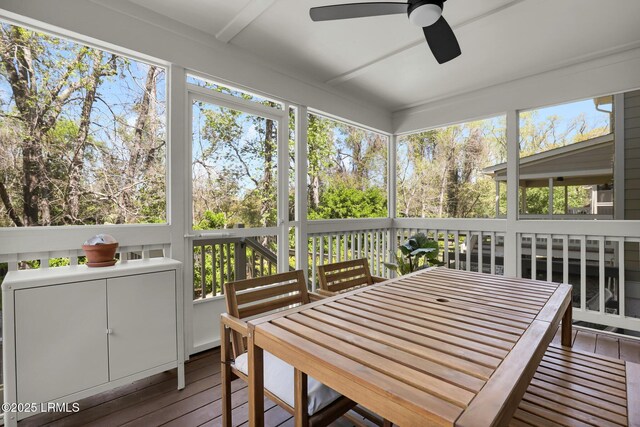 sunroom with outdoor dining area and a ceiling fan