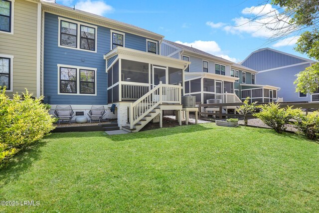 rear view of house with a lawn and a sunroom