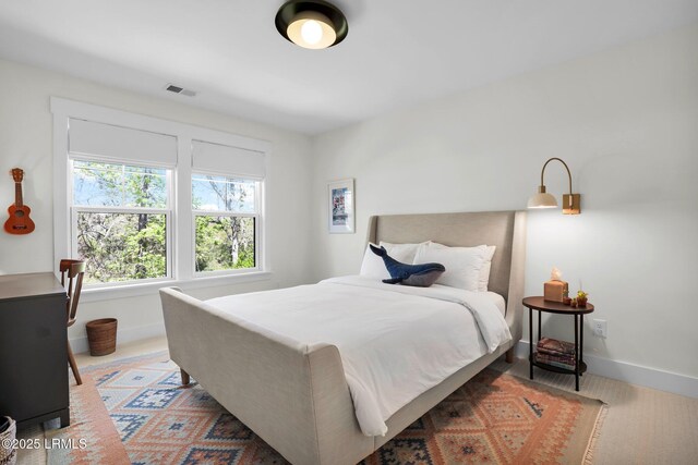 bedroom featuring baseboards and visible vents
