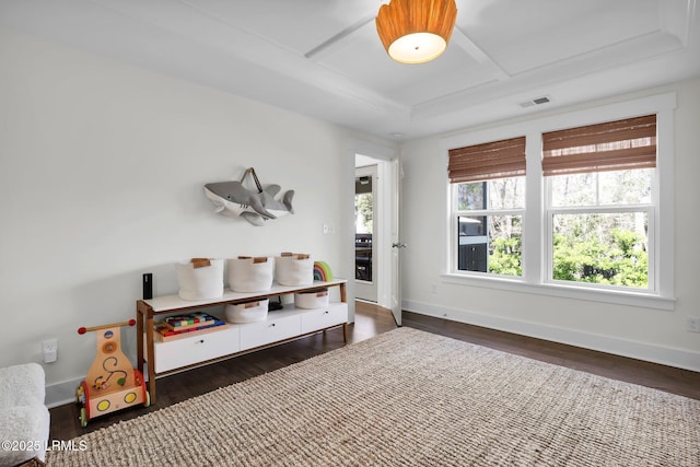 bedroom featuring baseboards, visible vents, wood finished floors, and a raised ceiling