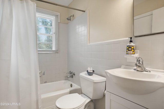 full bathroom featuring shower / bath combo, tile walls, vanity, and toilet