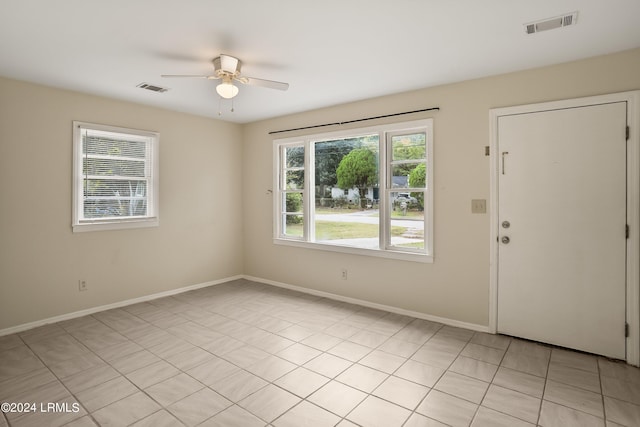 spare room featuring light tile patterned floors, plenty of natural light, and ceiling fan