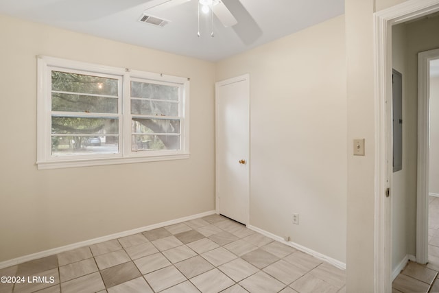 tiled spare room with ceiling fan