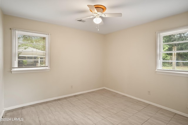 unfurnished room with a wealth of natural light and ceiling fan