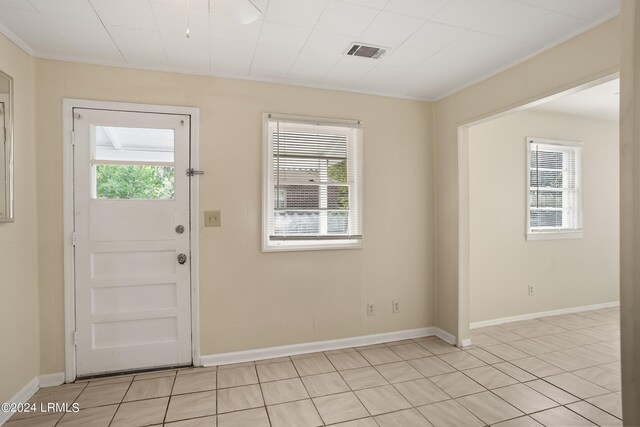 tiled foyer entrance featuring crown molding