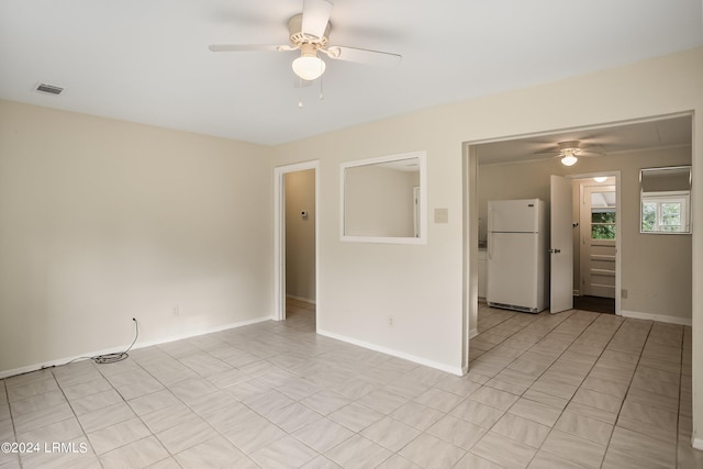 tiled empty room featuring ceiling fan