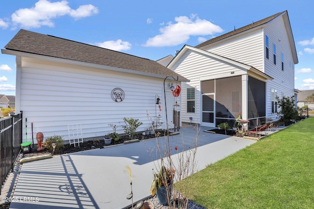 exterior space with a yard, a sunroom, a patio, and fence