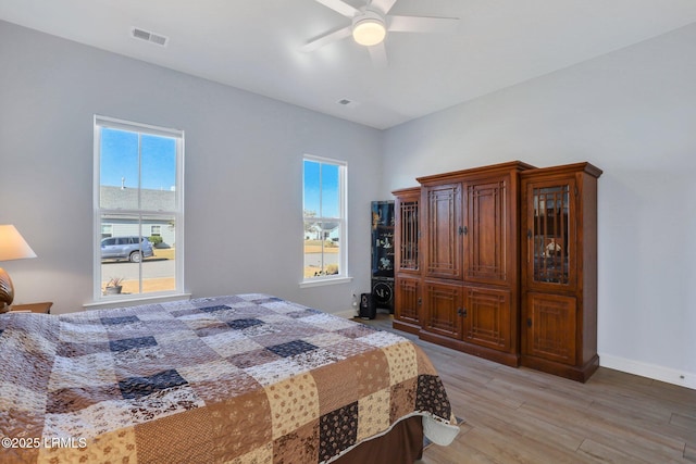 bedroom with baseboards, multiple windows, visible vents, and light wood finished floors