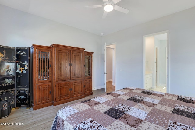 bedroom with a ceiling fan, ensuite bath, and light wood finished floors