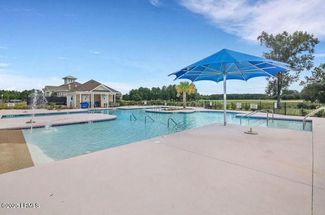 community pool with a patio area and fence