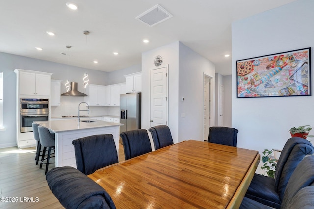 dining room with light wood-type flooring, visible vents, and recessed lighting