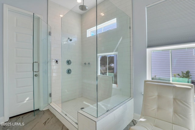 bathroom featuring marble finish floor and a stall shower