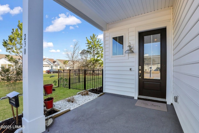 property entrance featuring a yard and fence