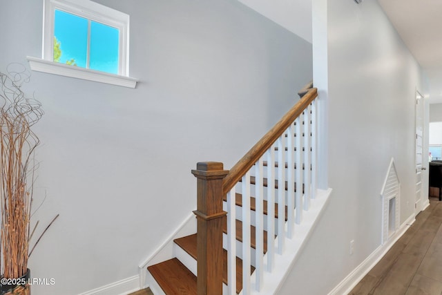 staircase with baseboards and wood finished floors