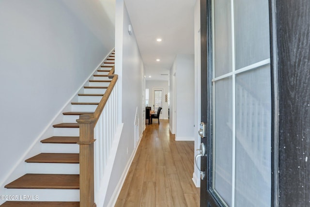 entrance foyer featuring baseboards, stairway, wood finished floors, and recessed lighting