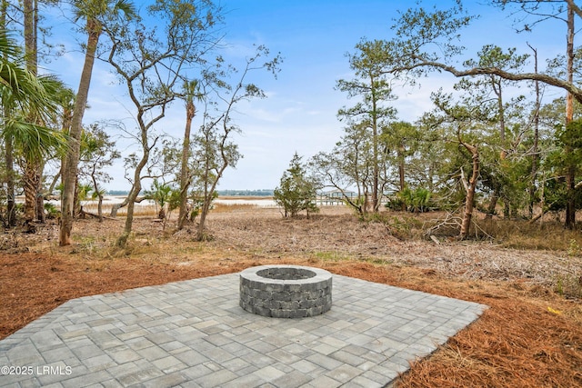 view of patio featuring a water view and an outdoor fire pit