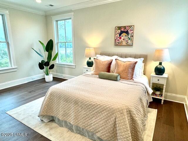 bedroom featuring crown molding and dark wood-type flooring