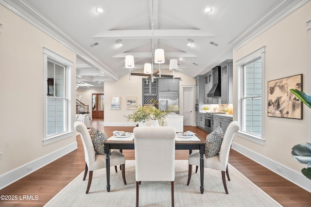 dining area with dark hardwood / wood-style flooring and lofted ceiling with beams