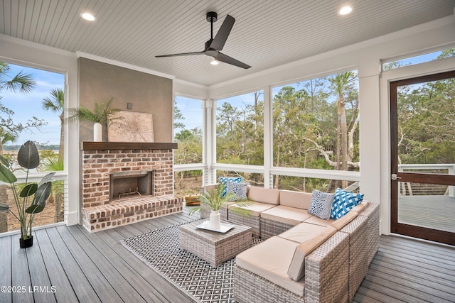 sunroom with an outdoor brick fireplace and ceiling fan