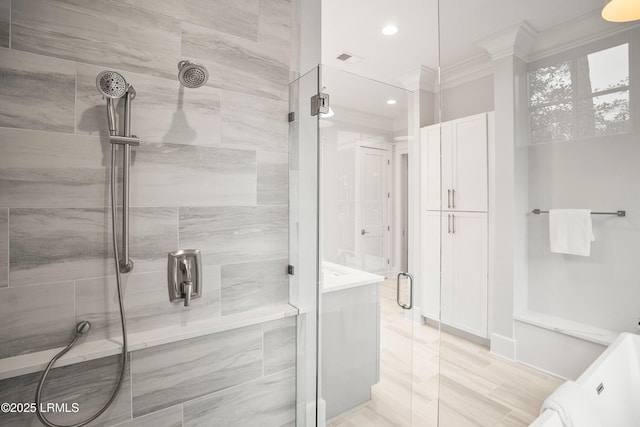 bathroom featuring crown molding and a shower with shower door