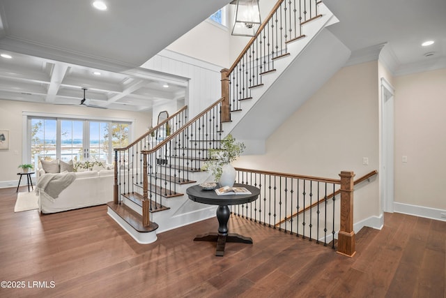 staircase with beamed ceiling, crown molding, coffered ceiling, and hardwood / wood-style floors