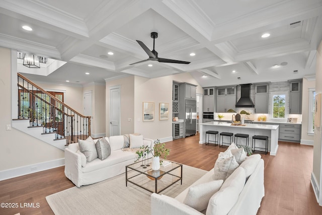 living room featuring coffered ceiling, hardwood / wood-style floors, and beamed ceiling