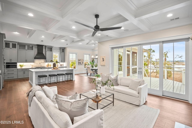 living room featuring beamed ceiling, ceiling fan, coffered ceiling, and light wood-type flooring