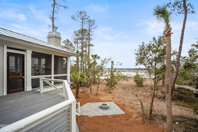 view of yard with a wooden deck, a sunroom, and an outdoor fire pit