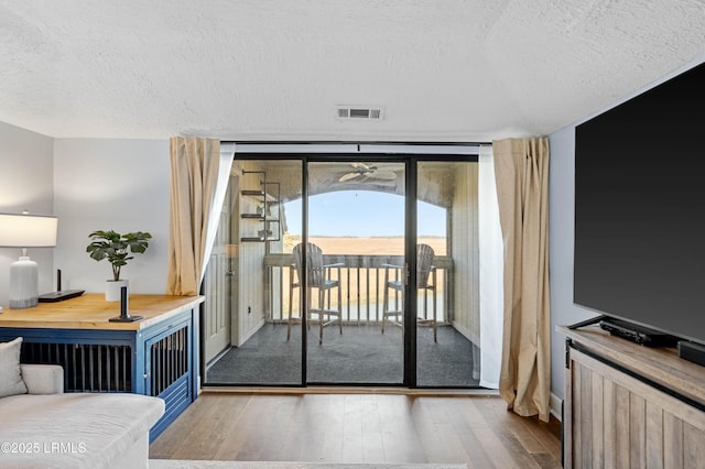 entryway with expansive windows, hardwood / wood-style floors, and a textured ceiling