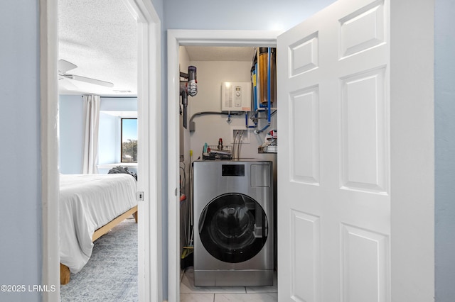 laundry area featuring light tile patterned flooring, ceiling fan, washer / dryer, and a textured ceiling