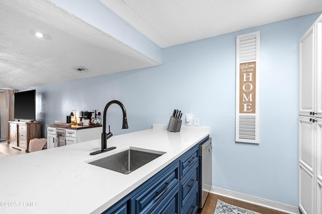 kitchen featuring blue cabinetry, sink, a textured ceiling, dark hardwood / wood-style floors, and dishwasher