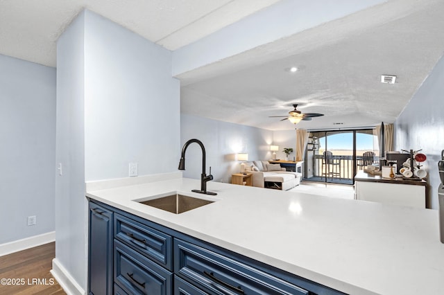 kitchen with blue cabinets, sink, a textured ceiling, dark hardwood / wood-style flooring, and ceiling fan